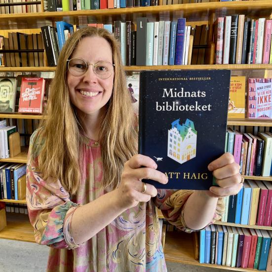Bibliotekar Johanne Søndergaard Louv med romanen Midnatsbiblioteket.