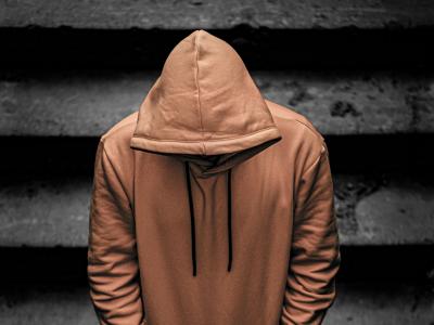 Ung person i gul hoodie går ned ad trappe med bøjet hoved.