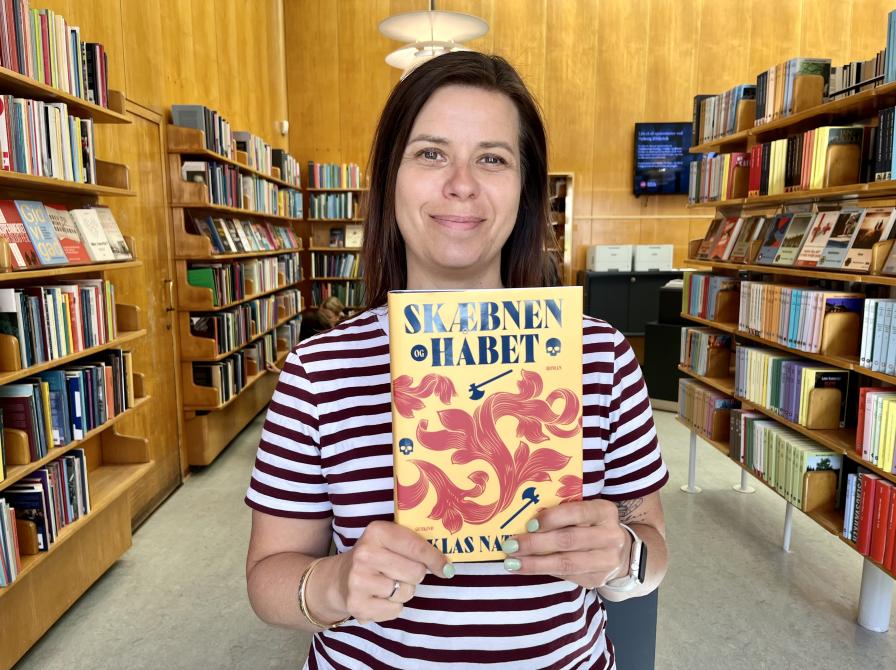 Bibliotekar Marianne Wismar Mühring med bogen "Skæbnen og håbet".