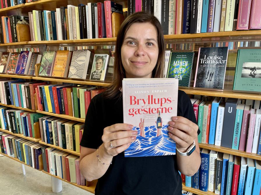 Bibliotekar Marianne Wismar Mühring med bogen "Bryllupsgæsterne"."